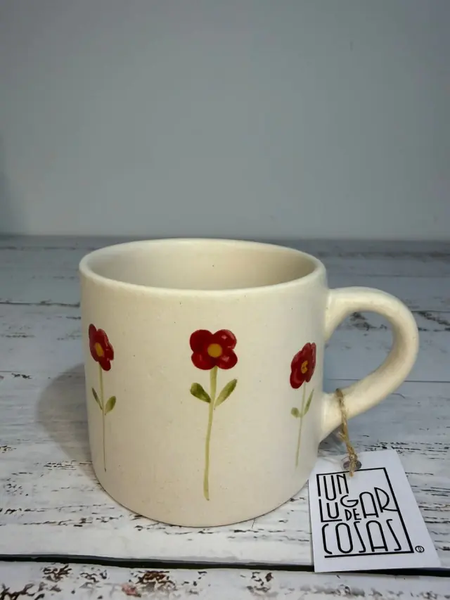 Taza de cerámica con flores rojas